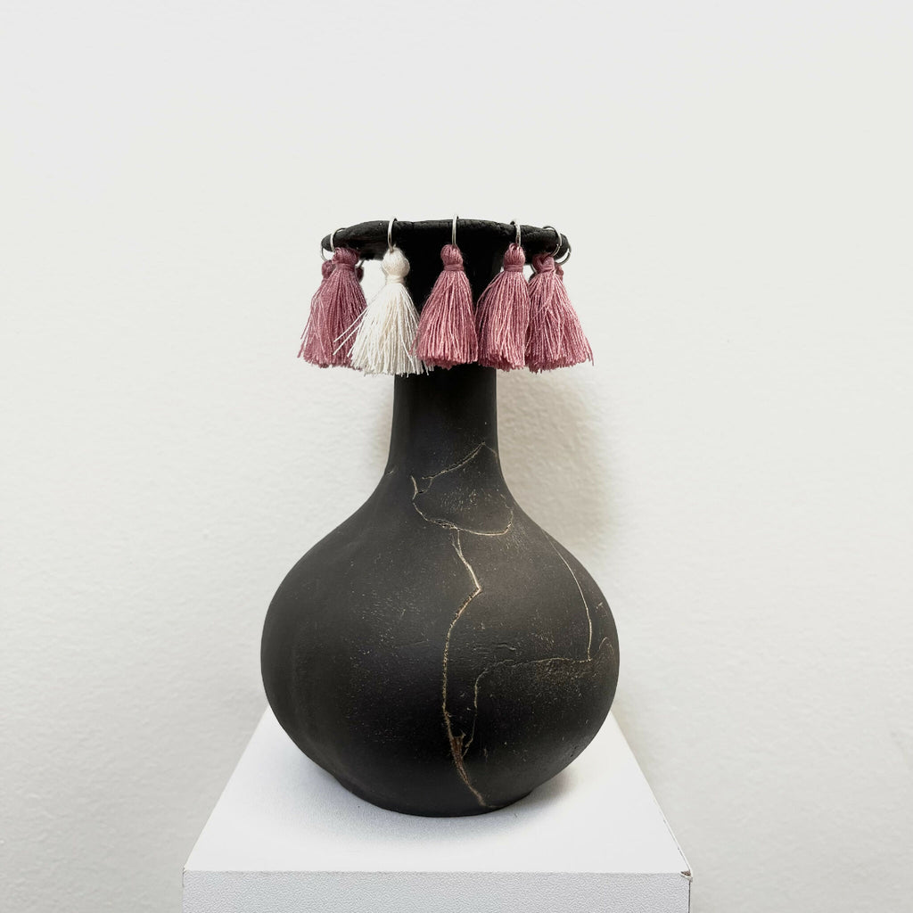 Soliflore noir en forme de vase avec pompons rose et blancs sur le col
