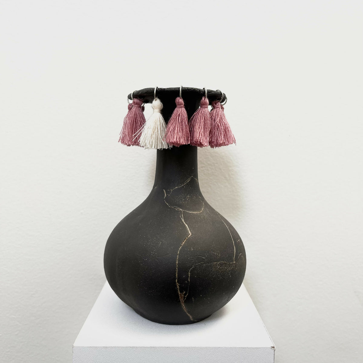 Soliflore noir en forme de vase avec pompons rose et blancs sur le col