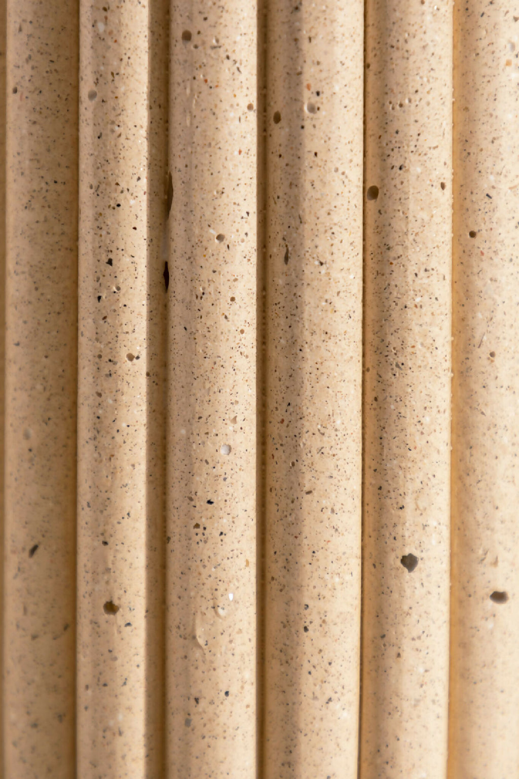 Gros plan du vase DÉDÉ sable, cannelures verticales granuleuses.