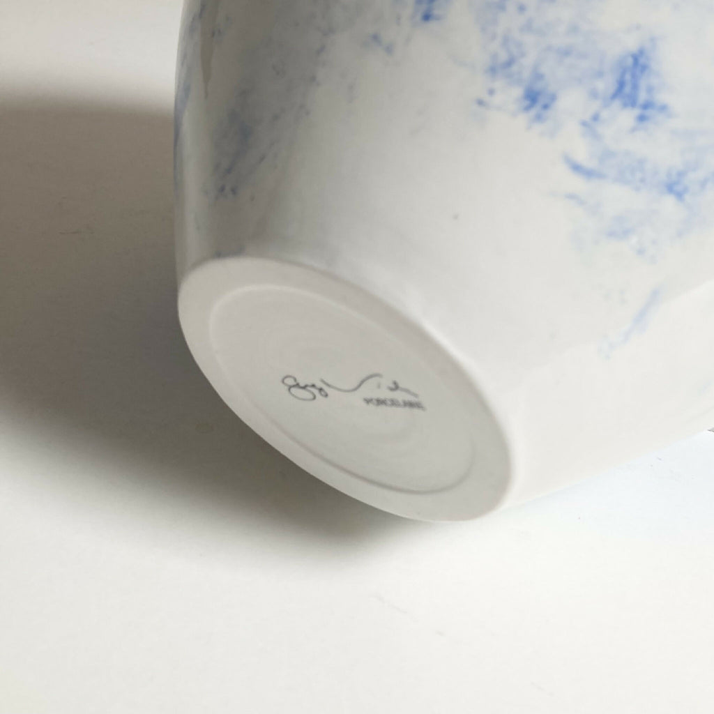 Base du vase blanc avec signature gravée et décor bleu sur le côté