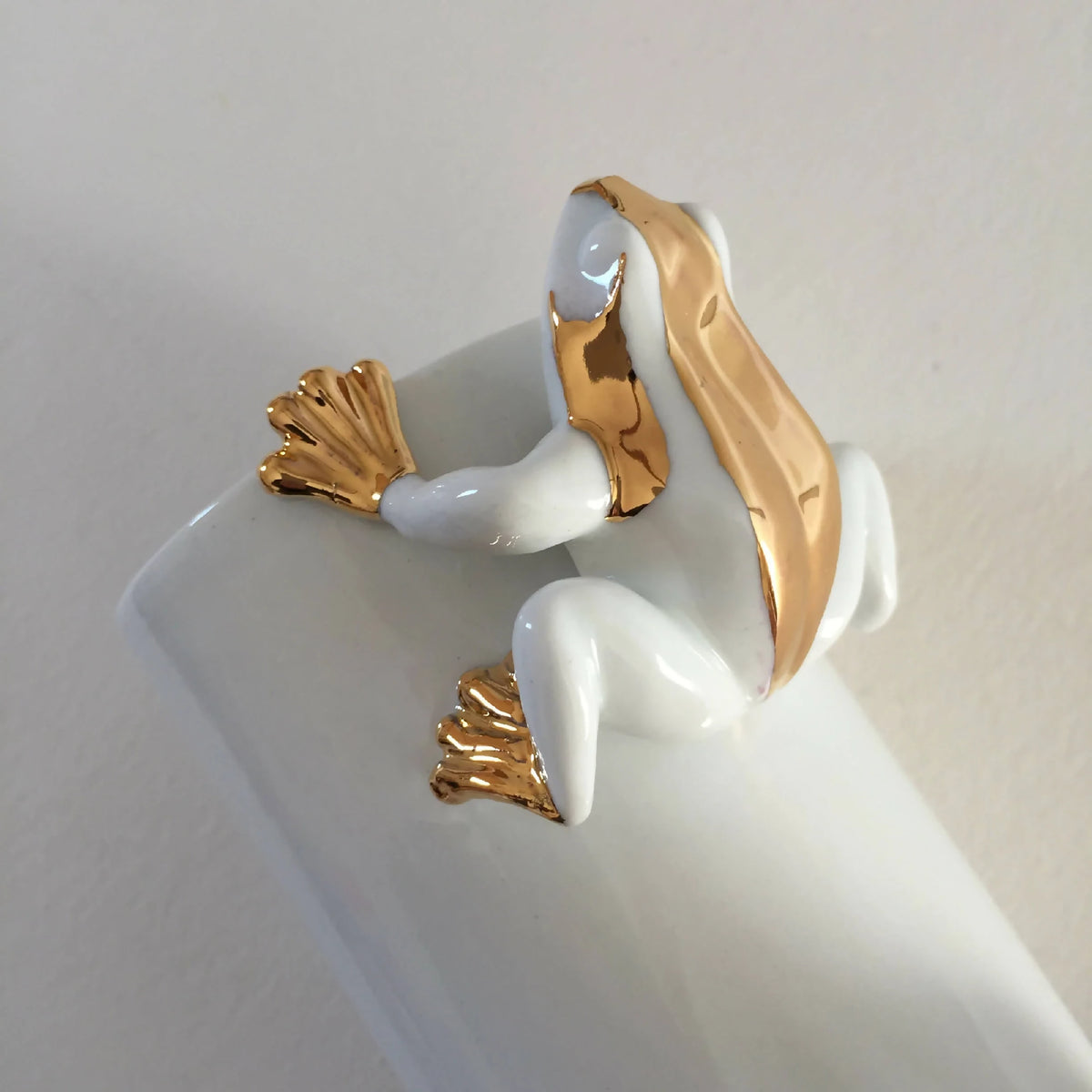 Vase en forme de grenouille blanche, tête et pattes avec finitions dorées.