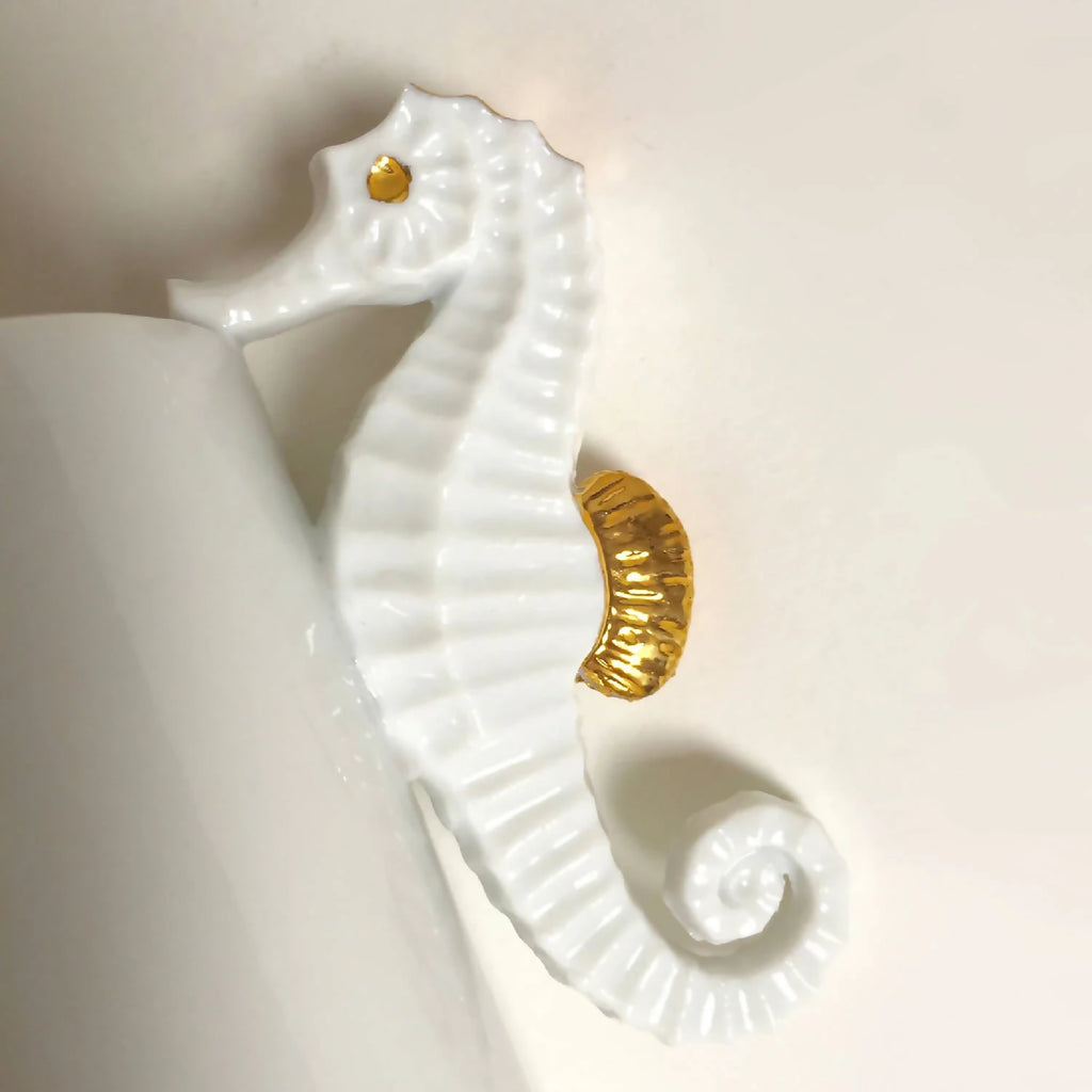 Vase blanc : gros plan hippocampe en relief, bordure et points dorés