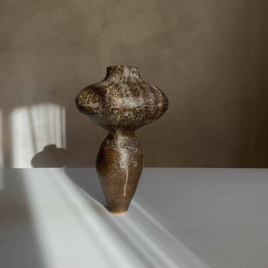 Vase sculptural brun foncé tacheté, silhouette arrondie et long goulot