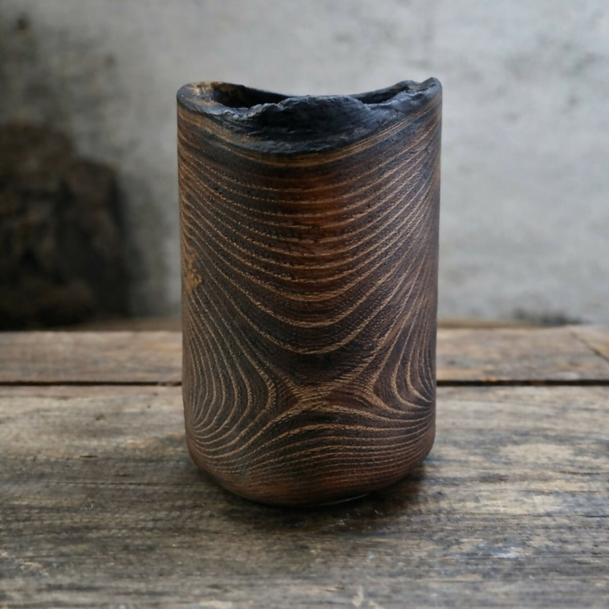 Vase cylindrique en céramique brun foncé à motifs de lignes ondulées, ouverture bleutée