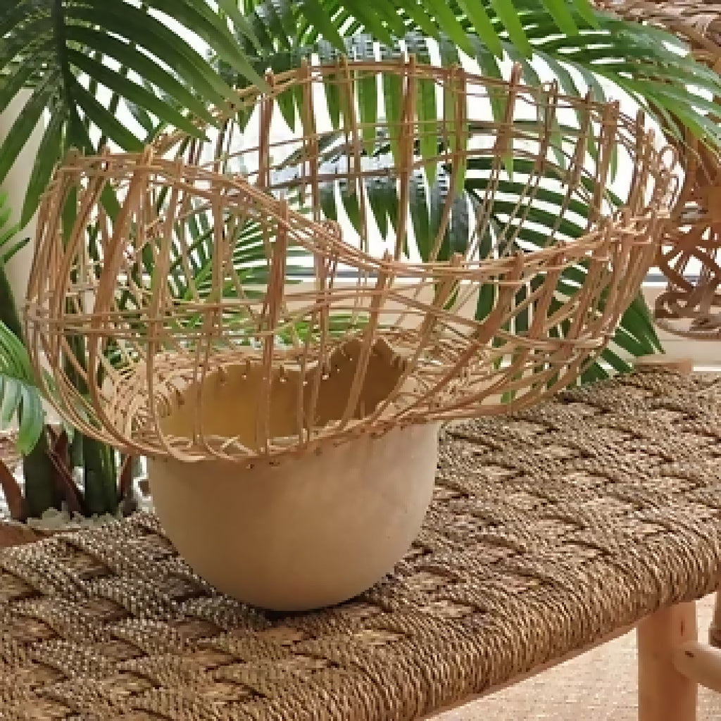Vase en céramique beige avec tressage en fibres et herbes vertes