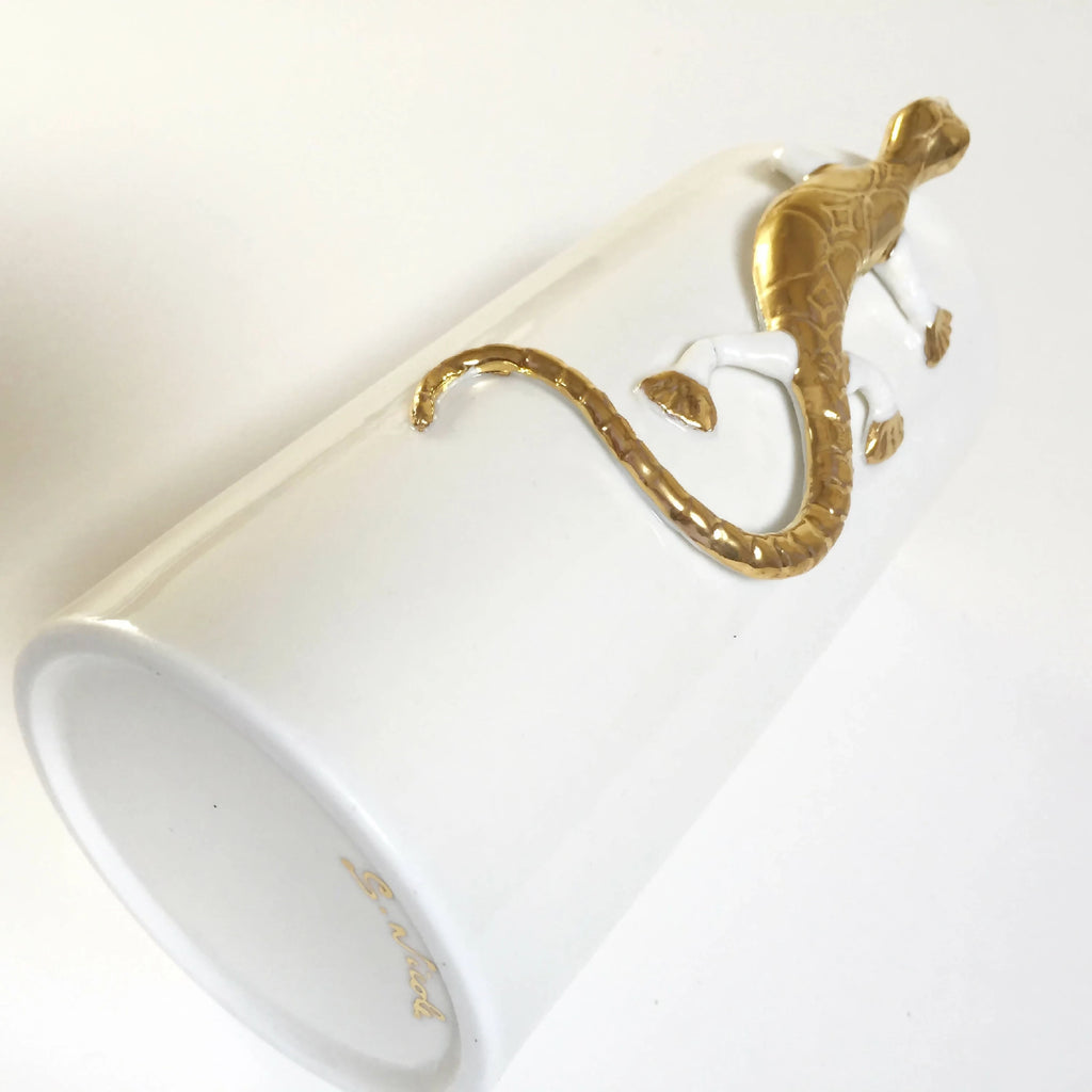 Vase blanc incliné avec salamandre dorée, vue du bord et du motif.