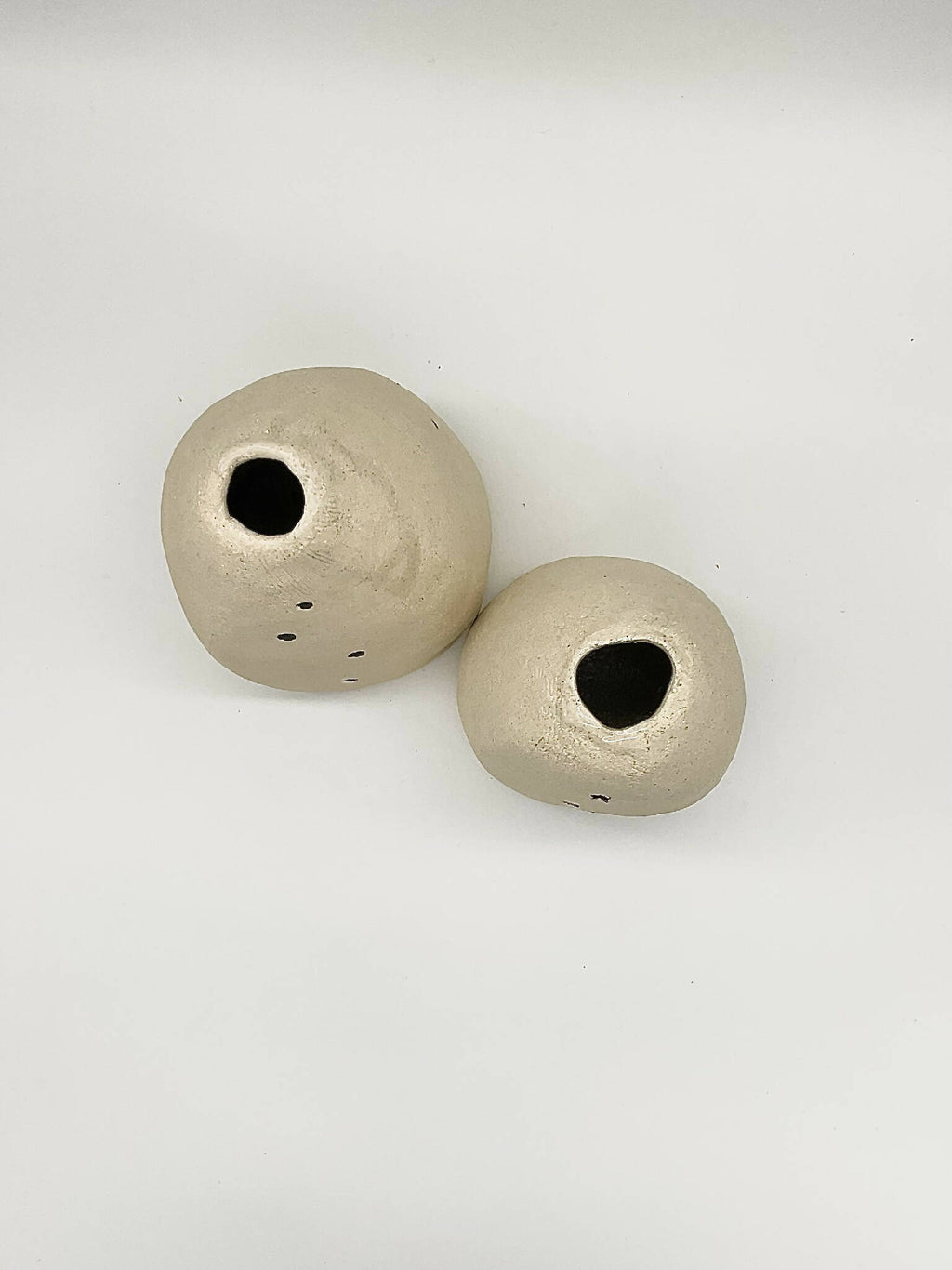 Paire de vases DUO coniques beige, vues des ouvertures rondes noires en haut.
