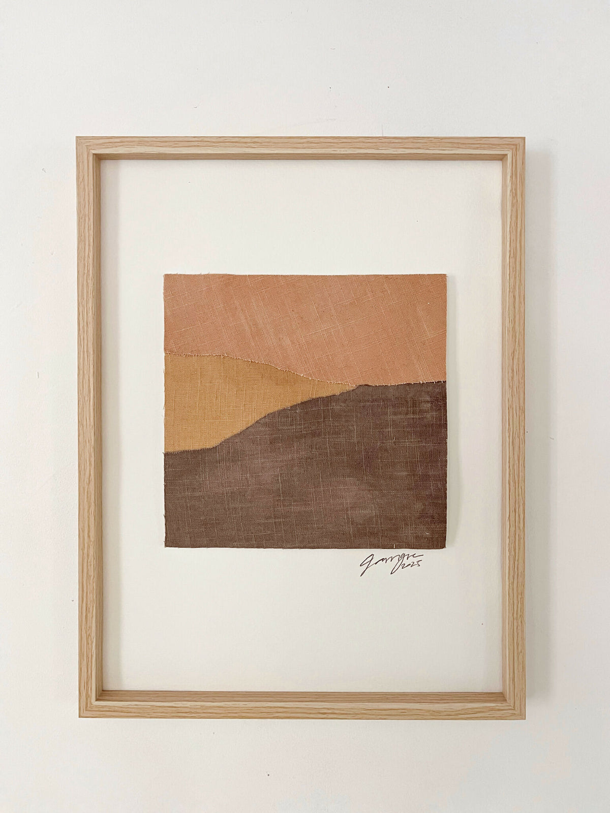 Collage textile abstrait de collines, tons terre cuite et brun foncé, cadre en bois.