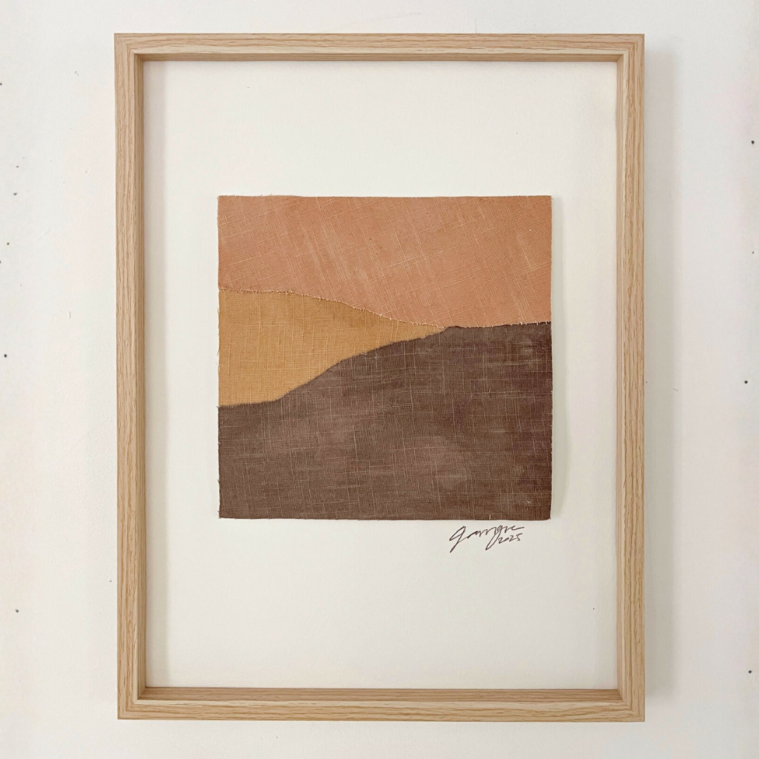 Collage textile abstrait carré avec signature, collines en terre cuite et brun foncé, cadre bois.