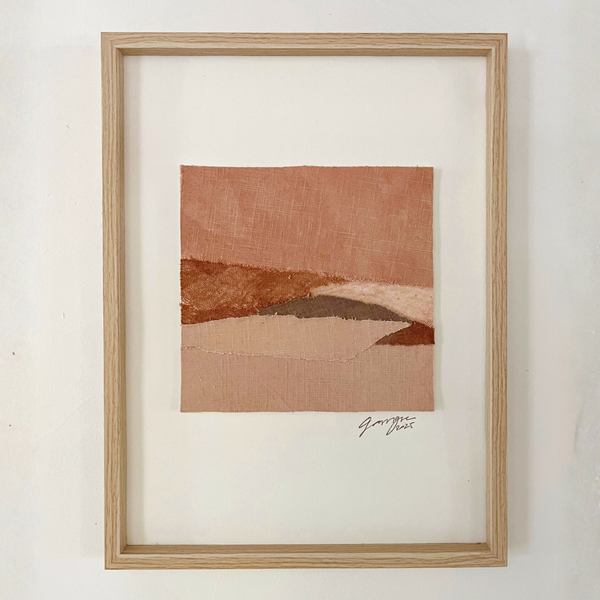 Collage textile abstrait en cadre bois clair, formes horizon, tons terre cuite et beige.
