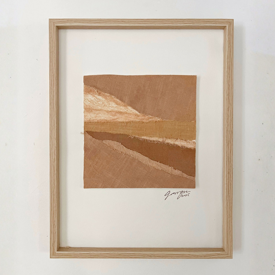 Collage textile encadré, bandes de tissus brun et sable formant des reliefs diagonaux.