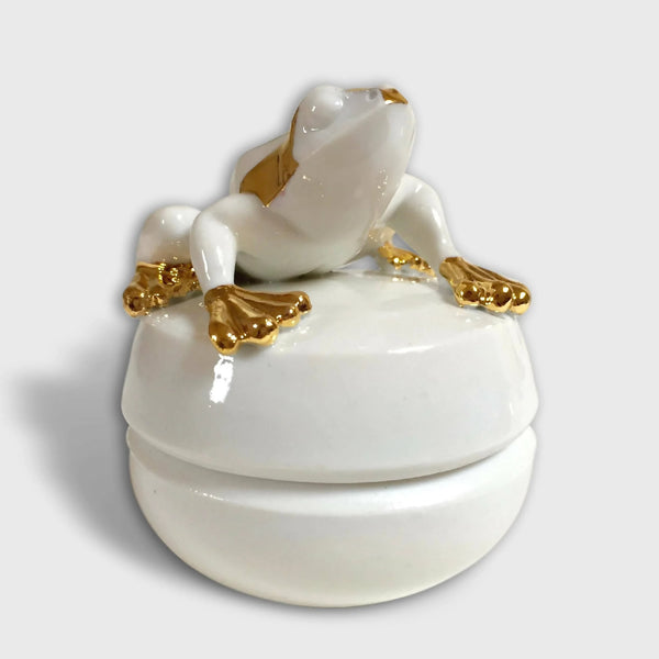 Boîte à bijoux en forme de grenouille blanche avec détails dorés, couvercle arrondi.