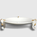 Centre de table hippocampe : plat blanc sur quatre figurines d’hippocampes dorées et grises.
