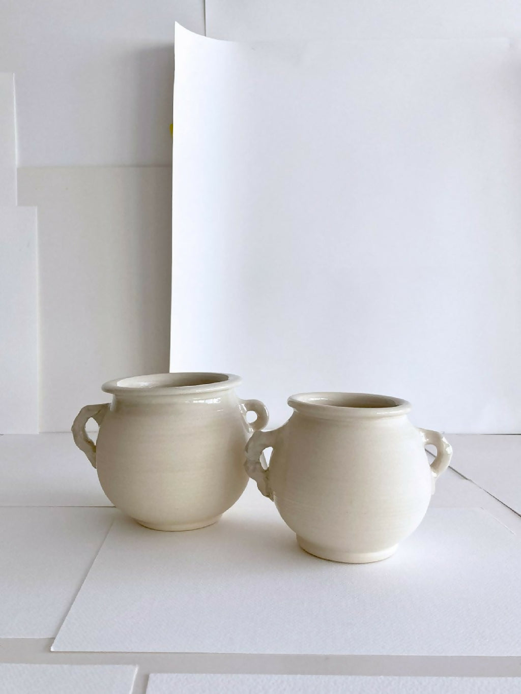 Paire de pots en grès beige clair, anses, forme ronde, vue de face