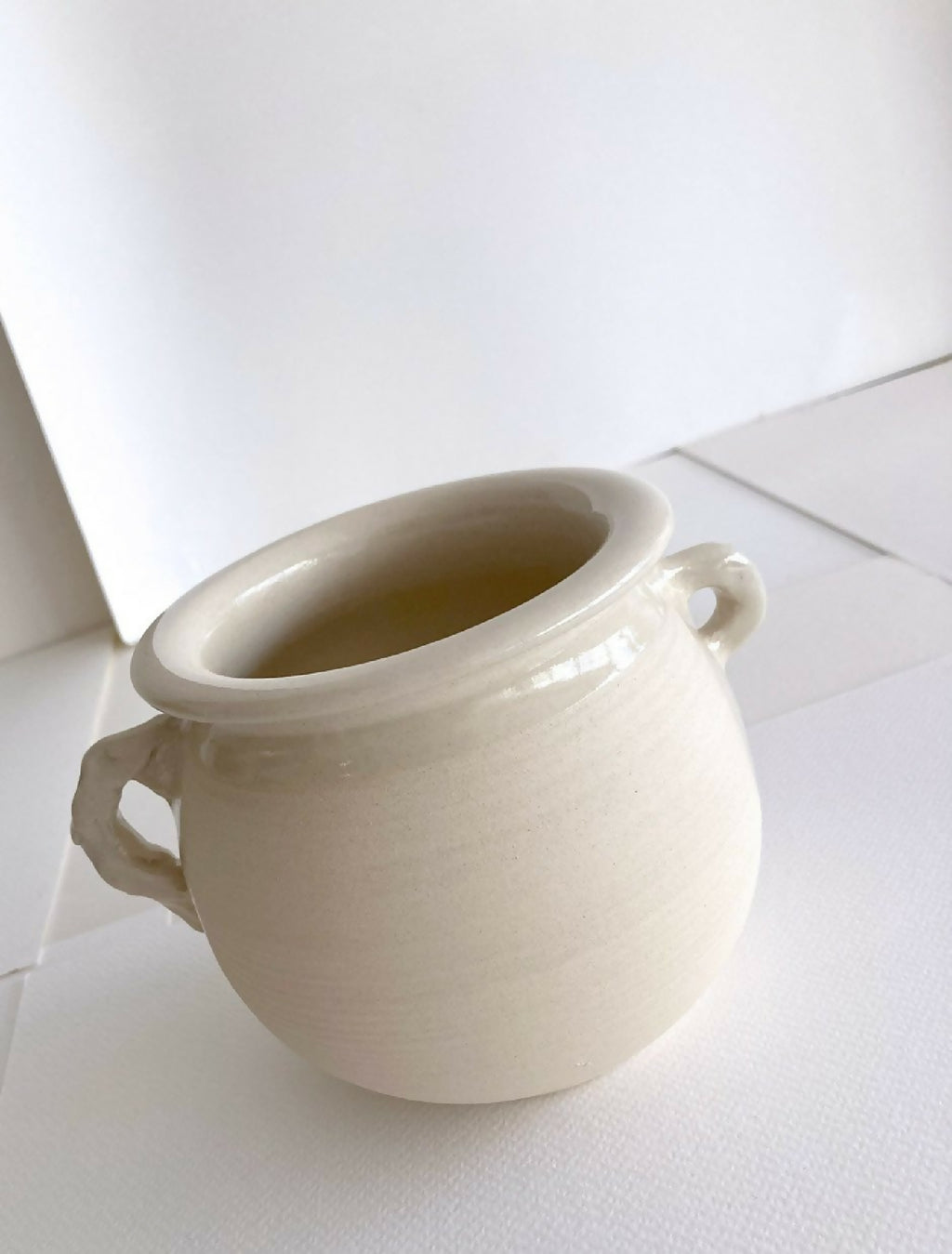 Pot en grès beige clair avec anses, ouverture large, vue rapprochée