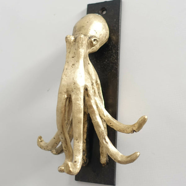 Porte-clés figurine pieuvre en métal doré sur plaque noire