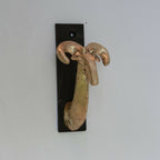 Porte-manteau mural en métal noir avec patère en forme de main, fixations visibles