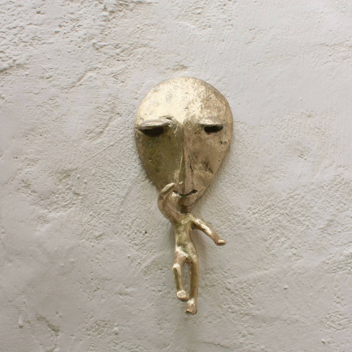 Porte-manteau mural en métal représentant un visage, avec poignée et bras levés