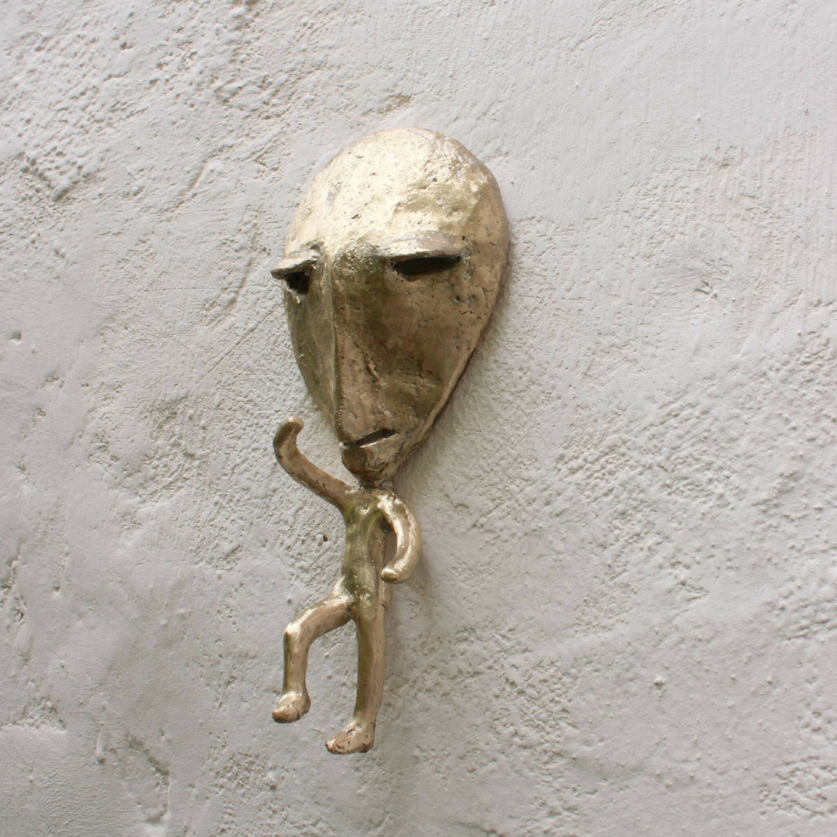 Porte-manteau mural en métal représentant un personnage, bras et jambe visible
