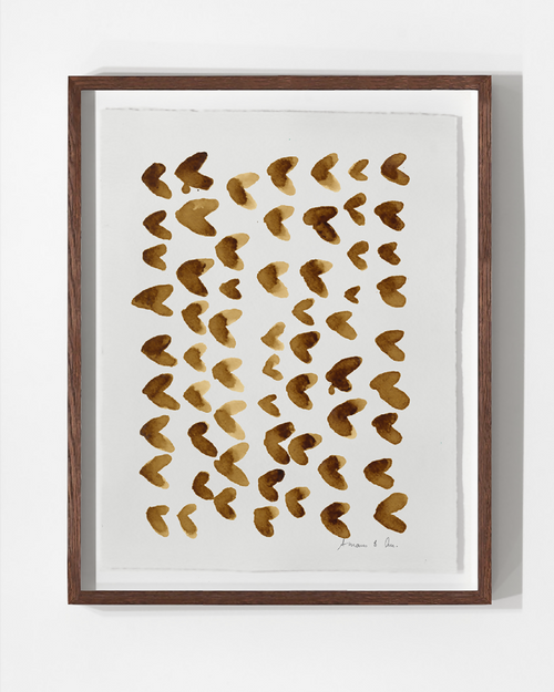 Tableau encadré en bois brun, motifs en empreintes de café marron sur fond clair