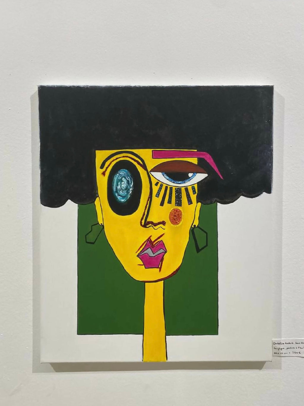 Peinture encadrée : portrait abstrait jaune, cheveux noirs et regard bleuté.