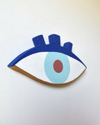 Décoration œil en bois, contour bleu, iris bleu clair et pupille rouge.