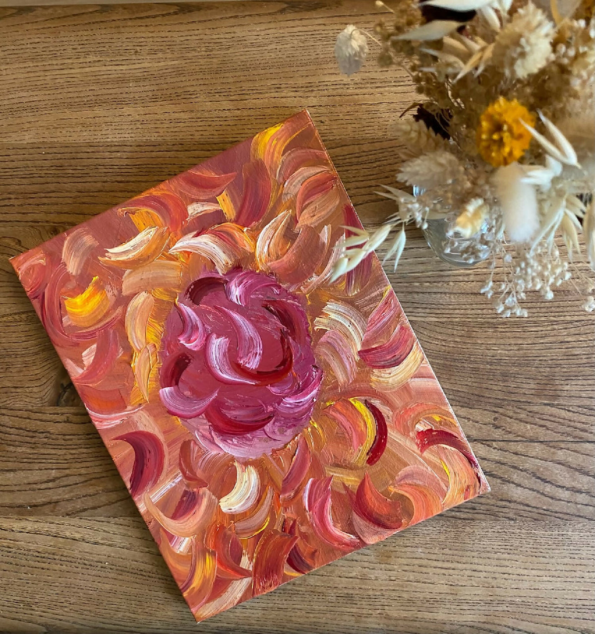Tableau décoratif à fleurs abstraites, peinture rose, orange et jaune sur fond texturé.