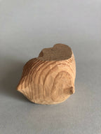Petit socle sculpté beige avec dessus brun, relief en stries, forme arrondie