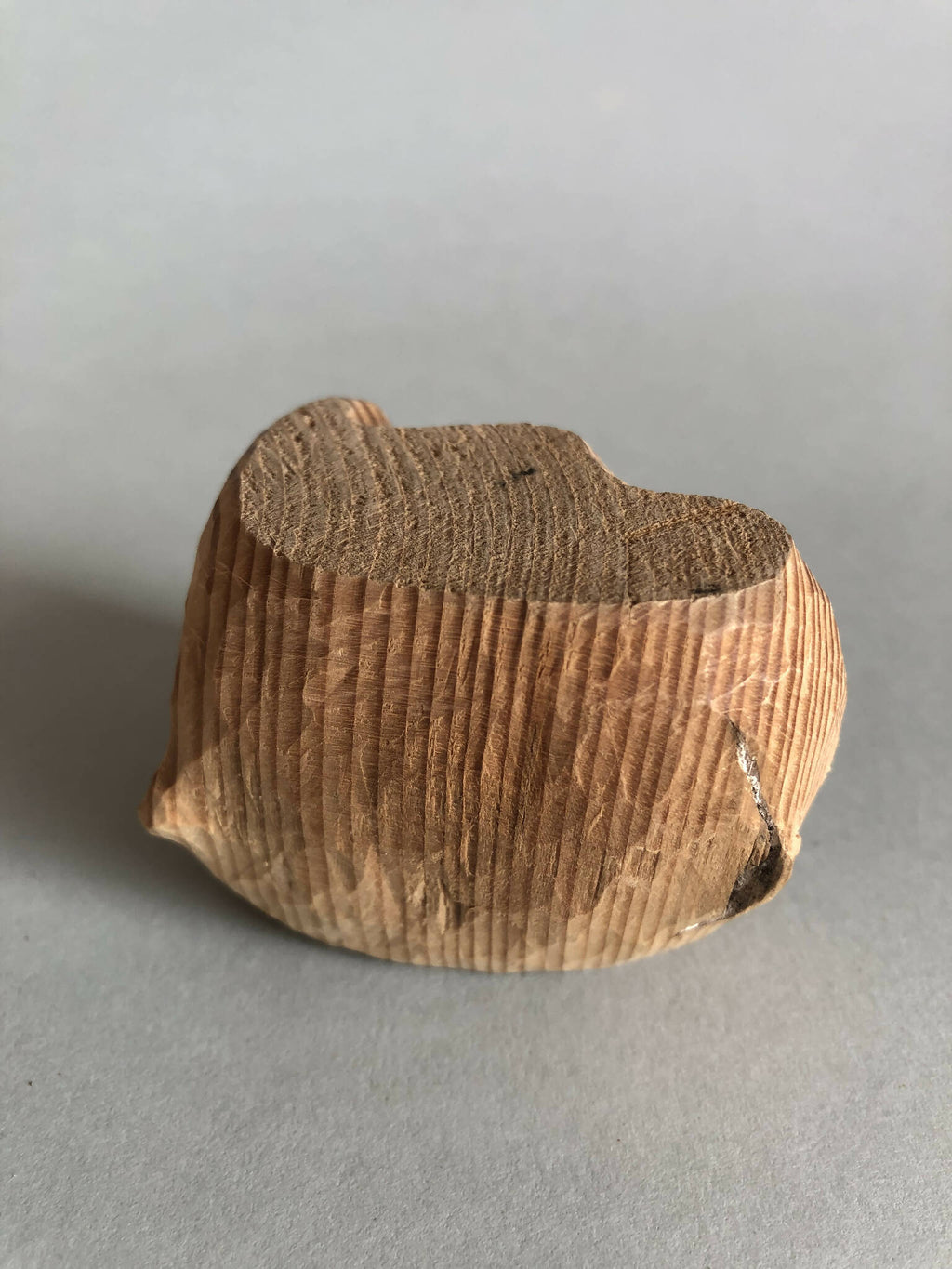 Petit socle sculpté brun, sommet en creux, relief strié sur toute la pièce