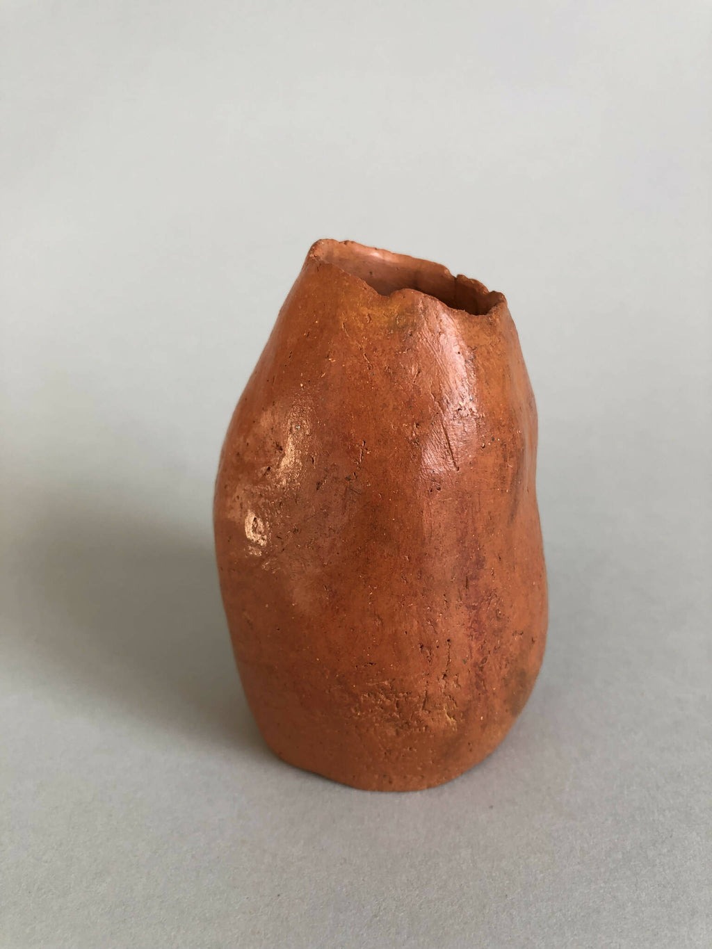 Petit vase en terre cuite orange, vue trois-quarts, ouverture évasée.