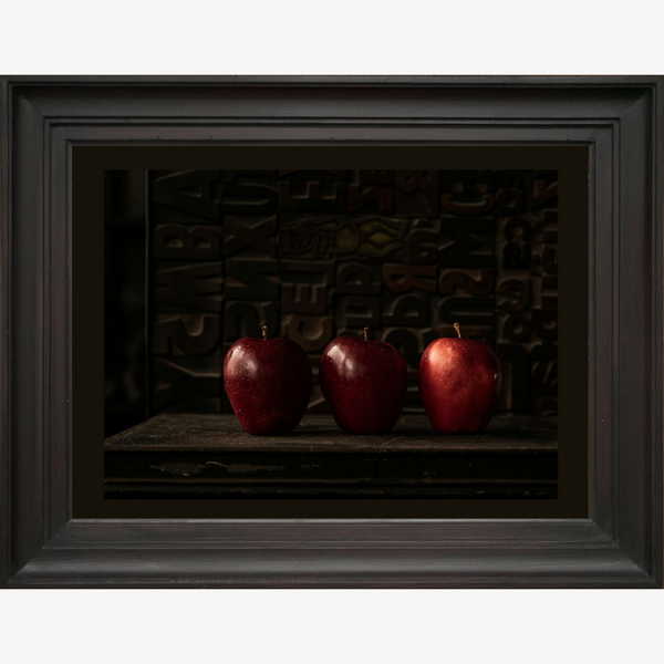 Nature morte encadrée avec trois pommes rouges, vues de face