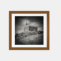 Photographie noir et blanc encadrée, chapelle de pierre sur une colline.