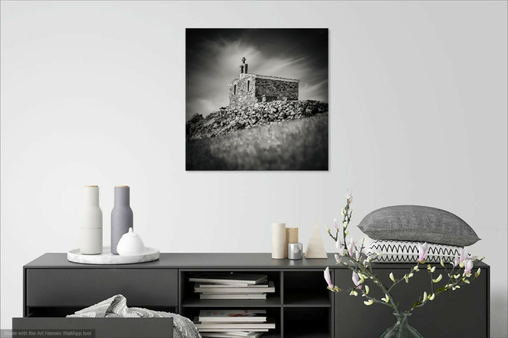 Photo encadrée noir et blanc montrant une chapelle en pierre sur une colline.
