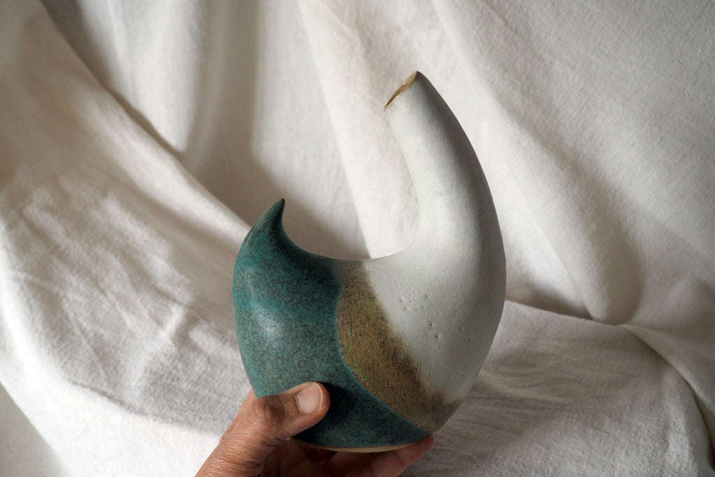 Pichet en céramique bicolore blanc et turquoise, tenu à la main, bec incurvé