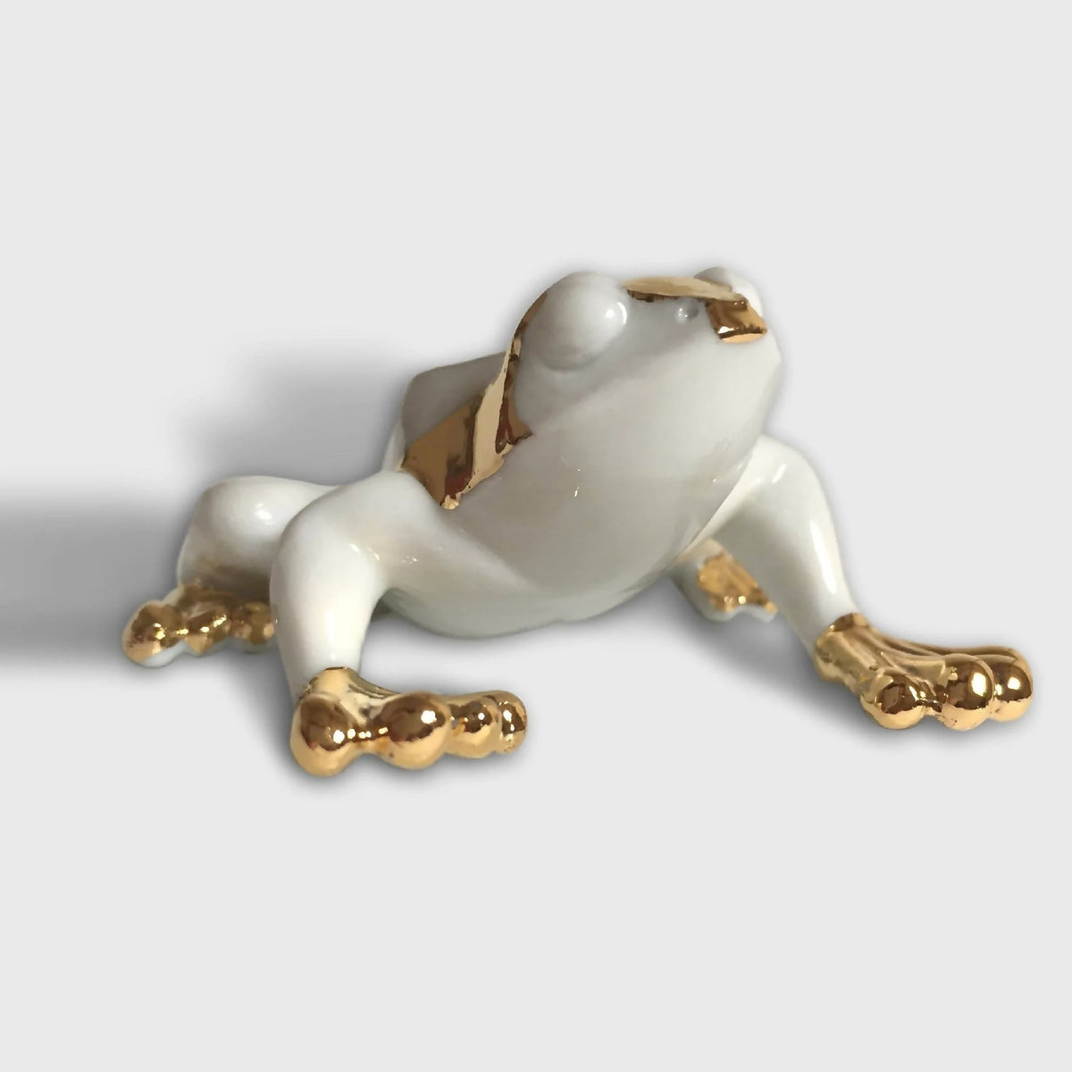 Figurine de grenouille en porcelaine blanche, finitions dorées aux pattes et au dos