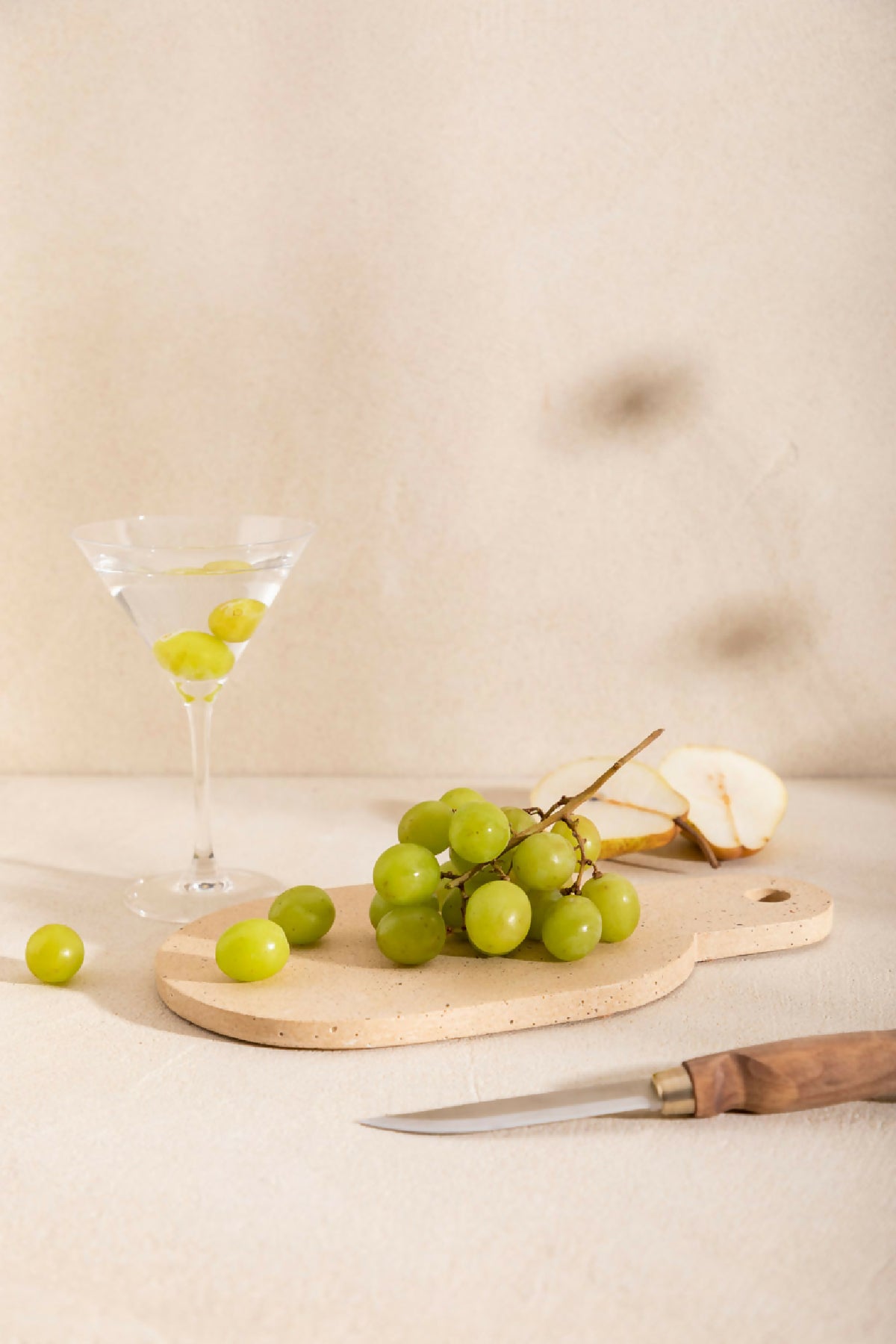 Planche à découper AIMÉE claire avec trou de prise, décorée de raisins et citron.
