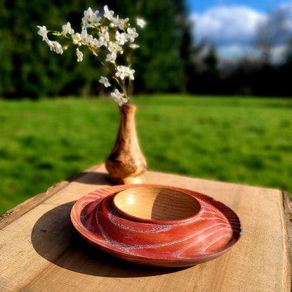 Coupe à fruits en bois ronde, motifs concentriques orange et bordeaux, bord moulé.