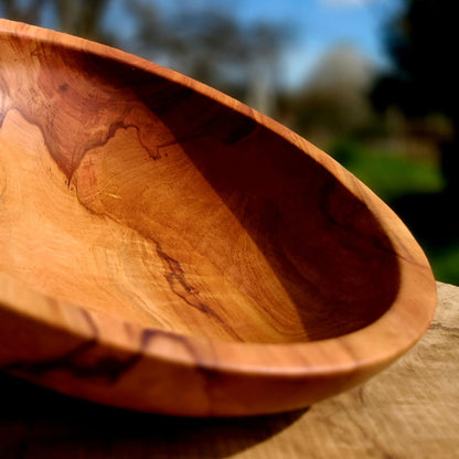 Plat en bois ovale vu de côté, intérieur creux et bord fin