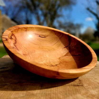 Plat décoratif en bois ovale, surface brun miel avec nœuds et veines