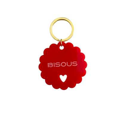 Gros plan du Porte-clé rouge à message positif : Bisous. Issu de l'artisanat français