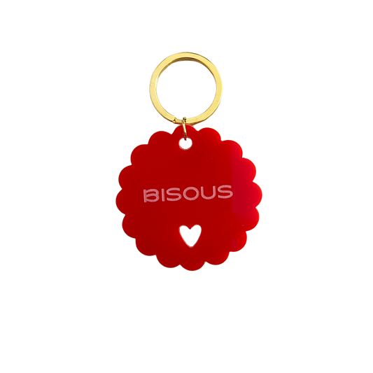 Gros plan du Porte-clé rouge à message positif : Bisous. Issu de l'artisanat français
