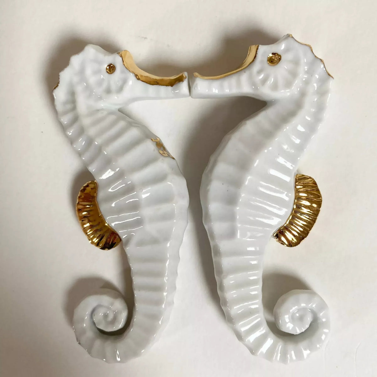 Porte-couverts hippocampe en porcelaine blanche, finition dorée, deux pièces.