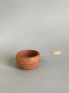 Petit pot en argile terracotta, ouverture ronde avec petit brin accroché