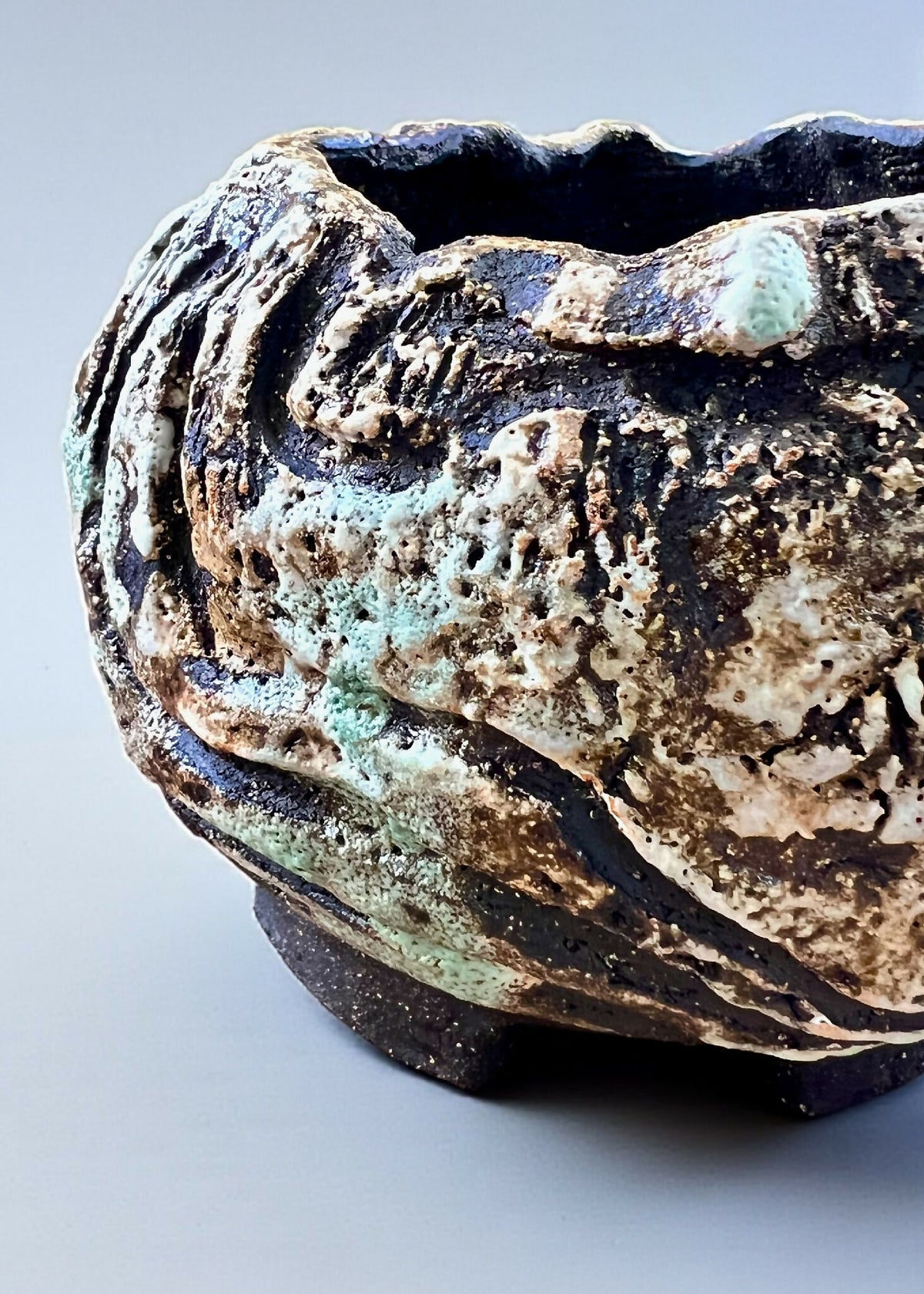 Pot à caudex en grès noir COLIMA, gros plan sur relief ondulé crème, bleu et brun.