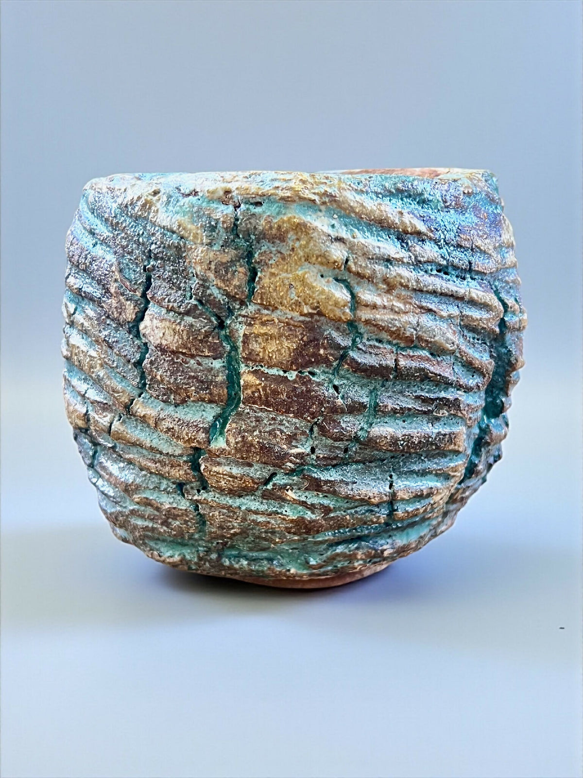 Pot en grès turquoise et brun, surface striée, forme arrondie, bord épais.