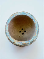 Base de pot en grès turquoise, intérieur brun granuleux, trois trous de drainage.