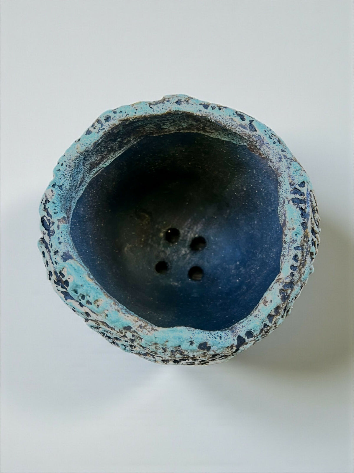 Pot en grès sculpté, vue intérieure, fond bleu foncé avec reliefs