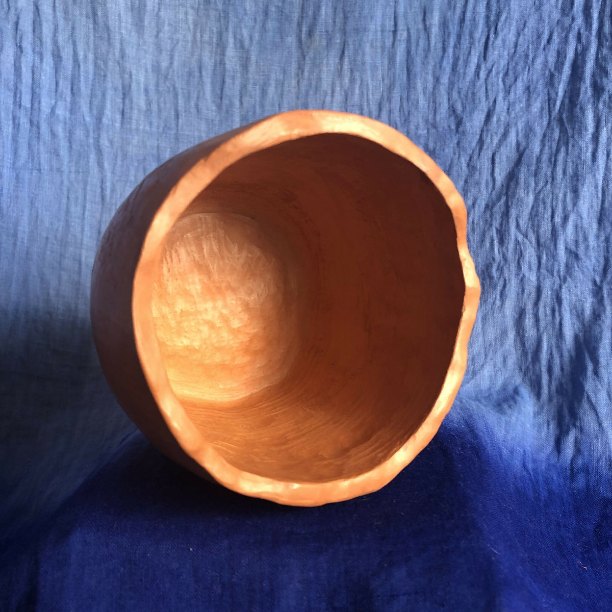 Pot en métal cuivré rouge, vue intérieure de l’ouverture arrondie.