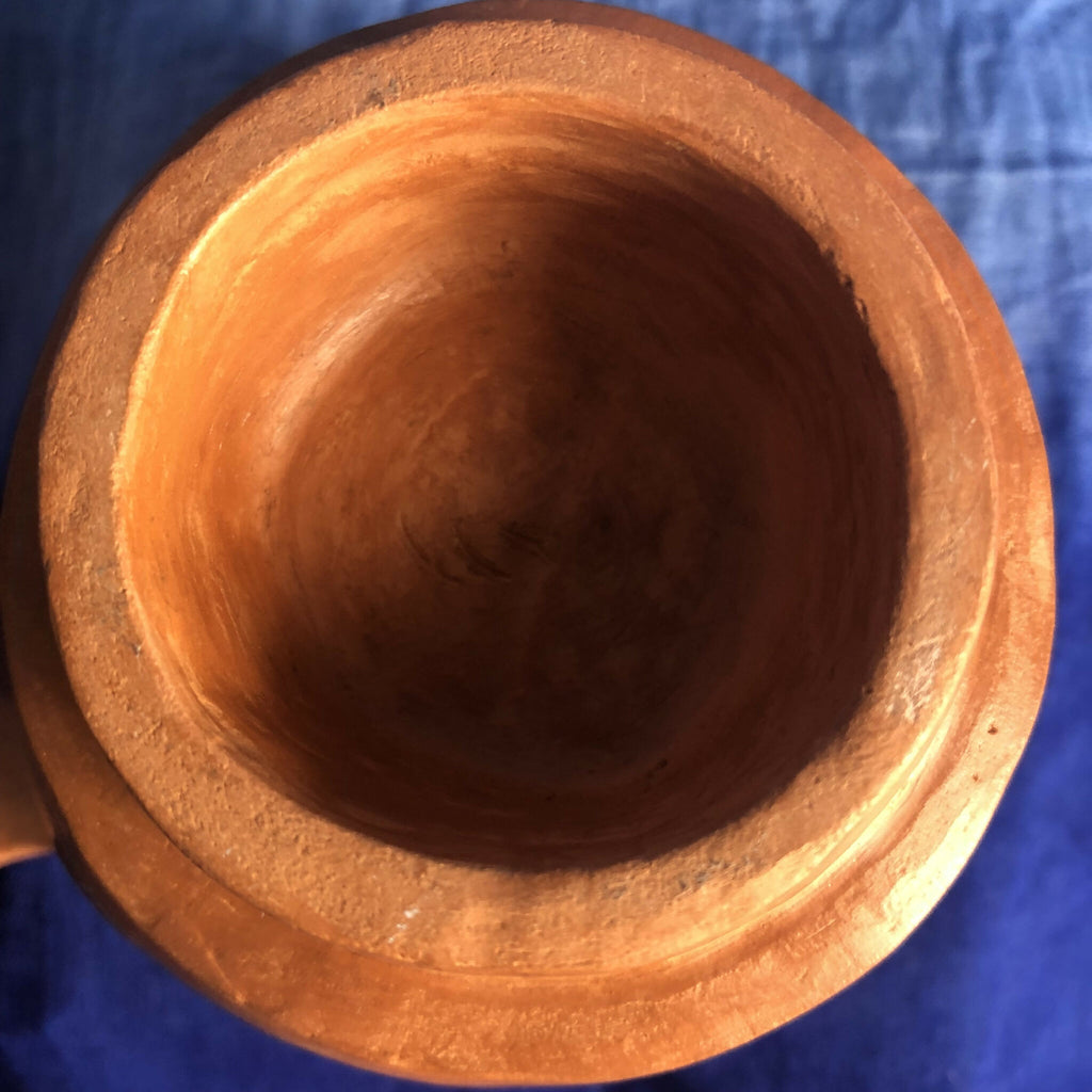 Pot céramique rouge-orangé, intérieur sombre et bord supérieur arrondi