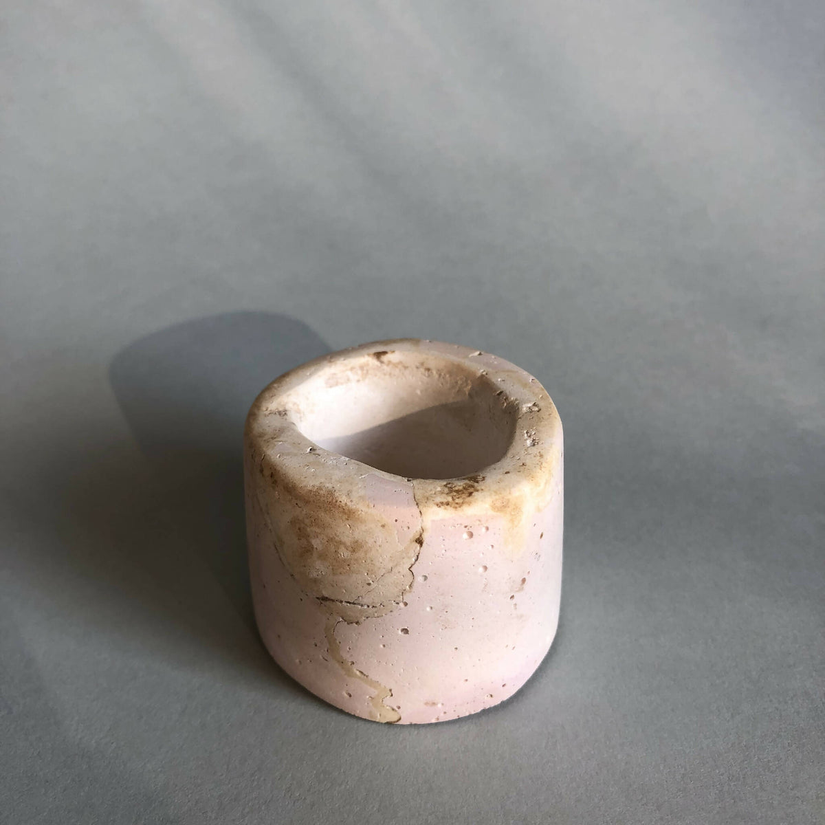 Petit pot en céramique rose pâle, vue de côté, surface fissurée
